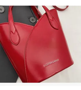 Detail of red leather bucket bag with silver lettering and premium stitching