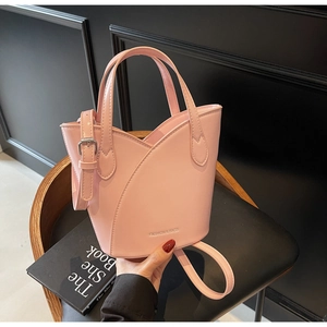Pink bucket bag with petal-like layers and adjustable strap on a black chair