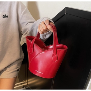 Detail of red tulip-shaped bucket bag with smooth leather finish and brand logo