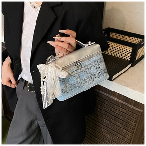 Detalle de bolso caja de mezclilla con diamantes, tope metálico y lazo de perlas