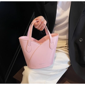 Close-up of pink bucket bag featuring unique layered petal cut design and top handles