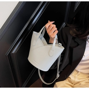 Close-up of light blue leather bucket bag with wave edge and Fashion & Bags embossing