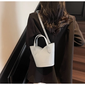 Detailed view of grey bucket bag with petal-style layers and adjustable crossbody strap