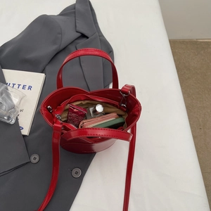 Macro shot of the red patent leather bucket bag interior showcasing its storage capacity