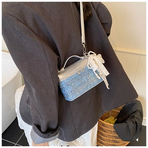 Minibolso caja de mezclilla y plata con dije de perlas llevado como bandolera