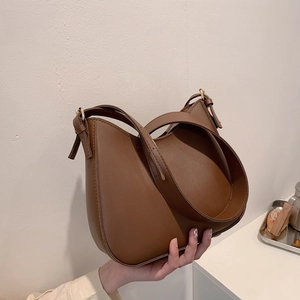 Brown semi-circle leather shoulder bag with wide strap and golden metal buckle