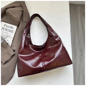 Detail einer dunkelroten Hobo-Tasche aus glänzendem Leder mit Vintage-Struktur