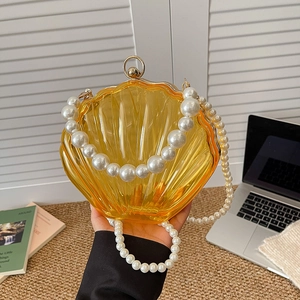 Transparent yellow shell evening bag with pearl chain strap and gold metallic frame clasp