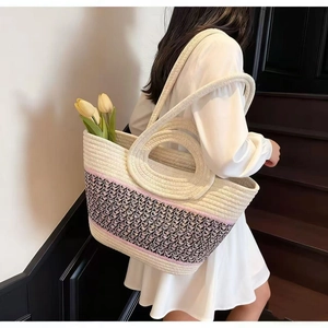 Detailed close-up of large straw tote bag featuring woven texture and round handle