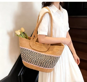 Detailed shot of large woven straw tote with leopard print base and comfortable double handles