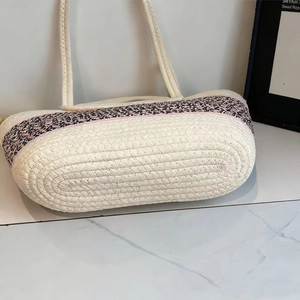 Detailed macro view of the sturdy hand-woven base of the large straw tote bag