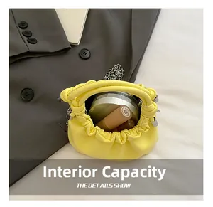 Internal capacity of the yellow pleated cloud bag showing lipstick and makeup accessories