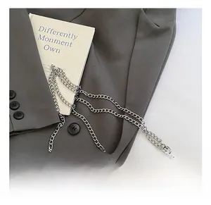 Detail of a bright yellow pleated handbag featuring multi-strand silver metal chains