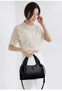 Détail d'un sac à main classique en cuir noir mat avec poignée et bandoulière