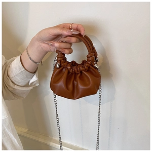 Detail view of brown PU leather pleated cloud bag with silver chain and top handle