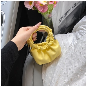 Detail of yellow mini PU leather cloud bag with knotted ring handle and silver chain