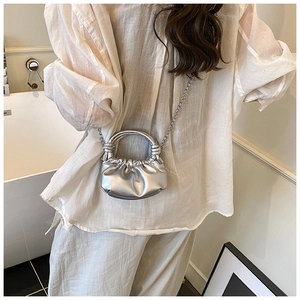 Detailed view of silver metallic pleated cloud bag with stylish chain strap and knot handle