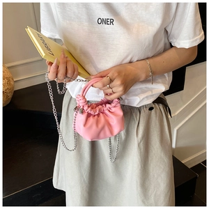 Detailed view of a pink pleated mini handbag with soft knotted handle and silver chain strap