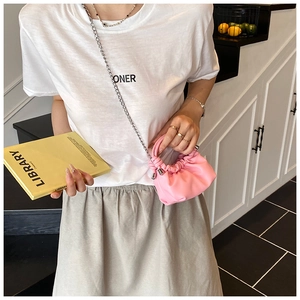Pink pleated cloud bag with metallic silver chain shown on a model in a casual outfit