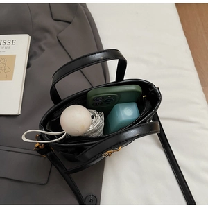 Internal view of black bucket bag showing space for phone, umbrella, and water bottle