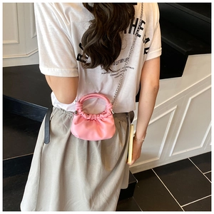 Close-up of pink ruched cloud bag featuring silver chain strap and top handle