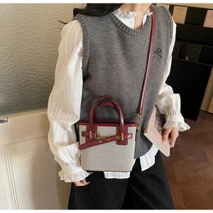 Detail of vintage bucket bag with off-white fabric and deep red leather trim