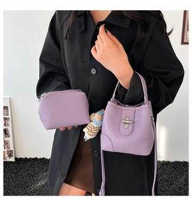 Detail of purple leather bucket bag set with matching pouch and bear charm shown on model
