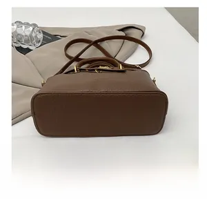 Detailed view of the wear-resistant base and stitching on a dark brown leather handbag