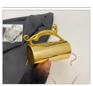 Detail of gold mirror cylinder clutch with leopard handle and metal chain strap