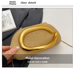 Detail of woven straw clutch with large golden C-letter hardware and chain strap