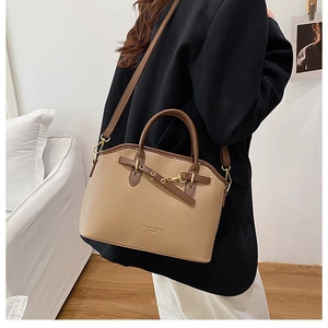Detail of khaki lychee grain leather handbag with gold buckles and fashion text engraving