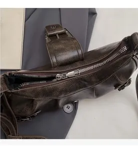 Detailed top view of a vintage dark brown textured leather shoulder bag with silver metal zipper