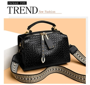 Détails du sac à main noir texturé avec bandoulière ethnique et finitions dorées
