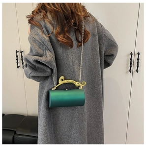 Detail of emerald green cylinder evening bag with gold panther handle and chain strap
