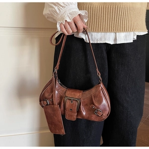 Detail of vintage brown leather crescent bag with metallic buckle and matching side pouch