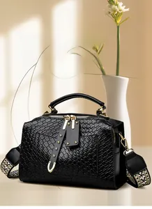 Détails d'un sac à main noir tressé vintage avec ferrures dorées et bandoulière