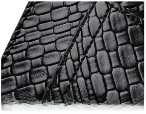 Gros plan du cuir noir embossé crocodile montrant les détails de double couture précise