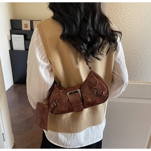 Brown retro underarm bag detail featuring vintage leather texture and decorative metal buckles