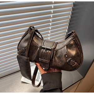 Detail of dark brown vintage faux leather shoulder bag with adjustable metal buckle straps