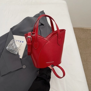 Chic red matte leather bucket bag with asymmetric layers and adjustable shoulder strap