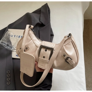 Detail of cream crescent hobo bag with pebbled leather texture and metal buckle