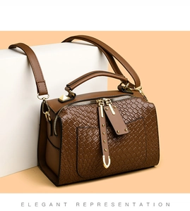 Détail d'un sac à main marron avec texture tressée, zips dorés et rivets métalliques