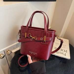 Retro burgundy leather bucket bag with gold hardware and maven & chic brand logo