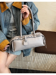 Detail of light purple pebbled leather baguette bag with silver buckles and metal eyelets