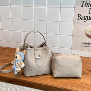 Chic beige lychee leather bucket bag with silver lock, mini pouch, and teddy bear charm