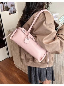 Detail of a pink cylindrical shoulder bag with pebble grain leather and silver hardware