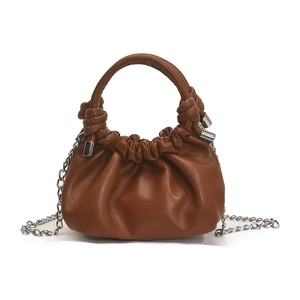 Brown pleated dumpling handbag with leather handle and silver chain strap on white background