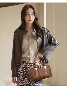 Asian model wearing a brown leather jacket and leopard skirt with a woven handbag