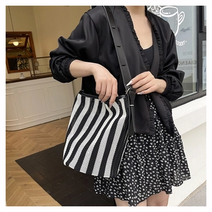 Close-up of black and white striped tote bag with mesh texture and black leather strap