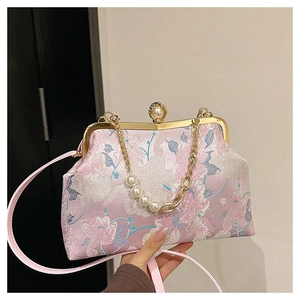 Détail du sac cheongsam en soie rose avec broderie florale et fermoir perle